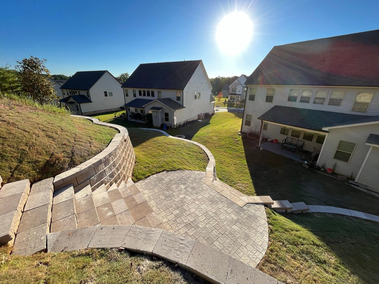 Terraced hillside paver patio with a curved seating wall in Gainesville, GA